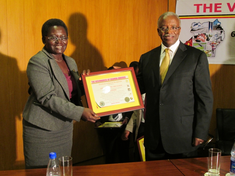 Rtn. Hon Prime Minister of Uganda, Amaama Mbabazi handing over the award to the Country Director-SG2000, Dr. Roselline Nyamutale
